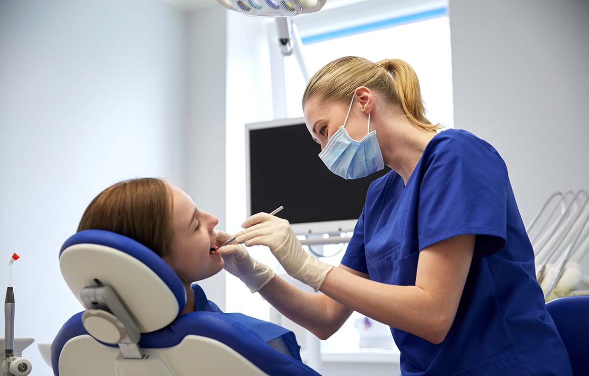 Dentist Checking Patient Teeth Inside Remote Mobile Dental Facility